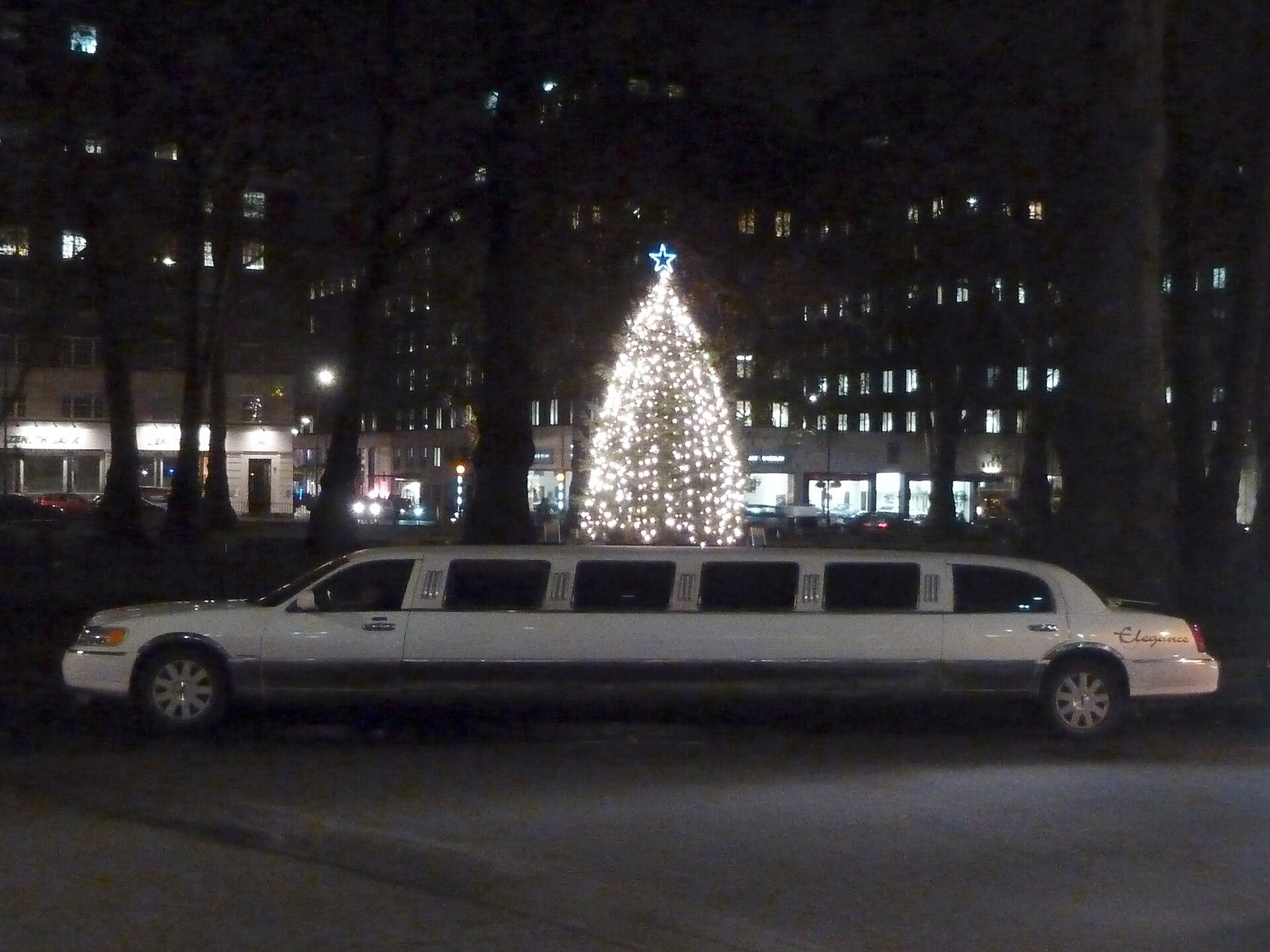 White stretch limousine on a city street at night